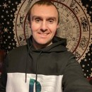 Photograph of Tommy, wearing a dark hooded sweatshirt