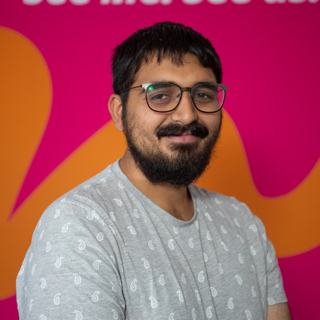 A young man smiles into the camera.