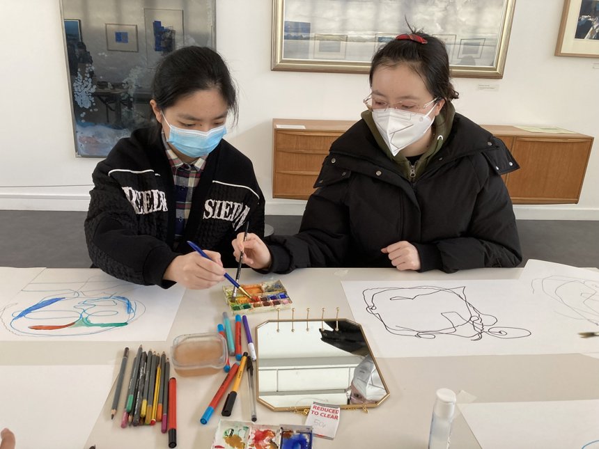 A photograph of two students painting