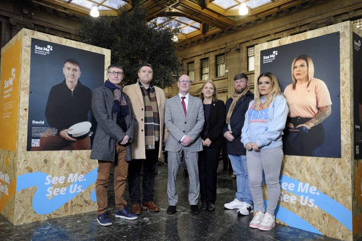 Four of the veterans featured in the photographs, with Minister for Mental Wellbeing and Social Care Kevin Stewart and See Me director Wendy Halliday