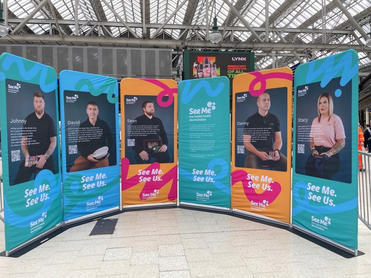 Six display stands arranged in a semi circle, featuring photographs of armed forces veterans.