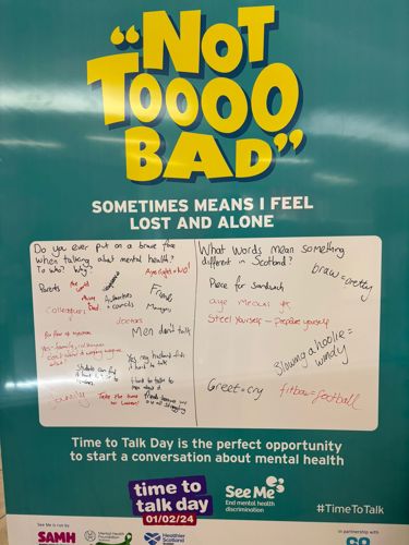 Image is of large board asking the questions "Do you ever put on a brave face when talking about mental health? To who? Why?" and "What words mean something different in Scotland?"